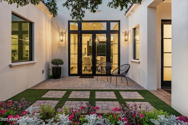 view of exterior entry featuring a patio and stucco siding