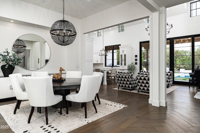 dining space featuring an inviting chandelier, recessed lighting, and a towering ceiling