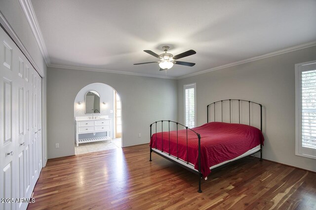 4079 E Shangri La Rd, Phoenix, AZ 85028 - bedroom with wood finished floors, multiple windows, crown molding, and arched walkways