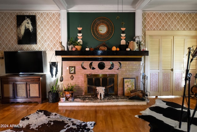 living room featuring wood-type flooring, crown molding, and a brick fireplace