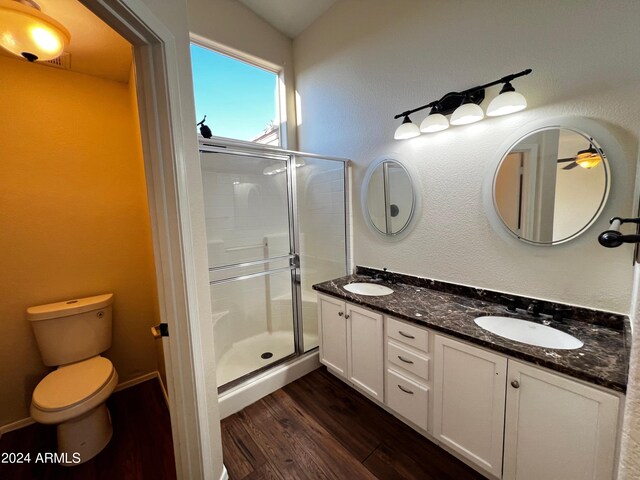 bathroom with vanity, hardwood / wood-style flooring, a shower with door, and toilet