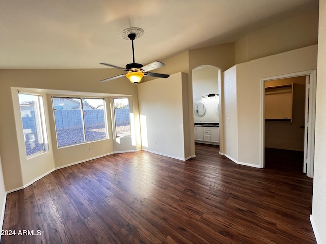 unfurnished living room with dark wood-type flooring, ceiling fan, and vaulted ceiling