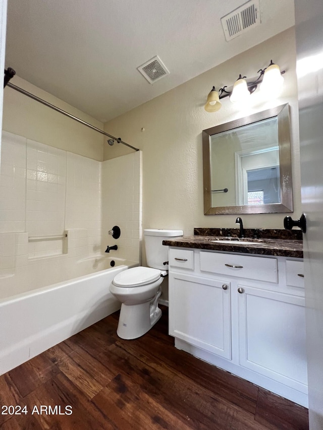 full bathroom featuring wood-type flooring, tub / shower combination, vanity, and toilet