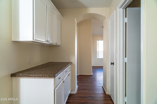 kitchen featuring white cabinetry and dark wood-type flooring