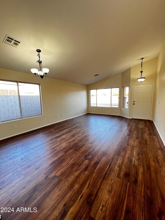 unfurnished living room with lofted ceiling, dark hardwood / wood-style flooring, and a notable chandelier