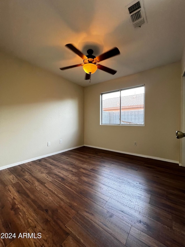 empty room with ceiling fan and dark hardwood / wood-style floors