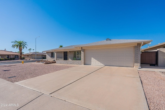 ranch-style home with a garage, concrete driveway, and brick siding