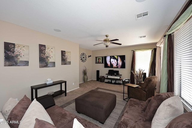 living room with carpet floors, ceiling fan, visible vents, and baseboards