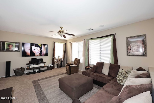 living area with carpet floors, visible vents, and a ceiling fan