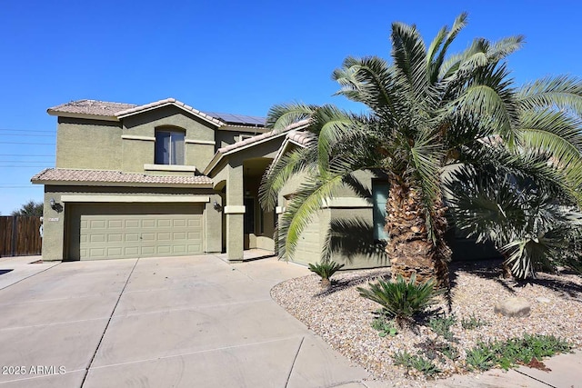 view of front of home with an attached garage, solar panels, a tile roof, driveway, and stucco siding