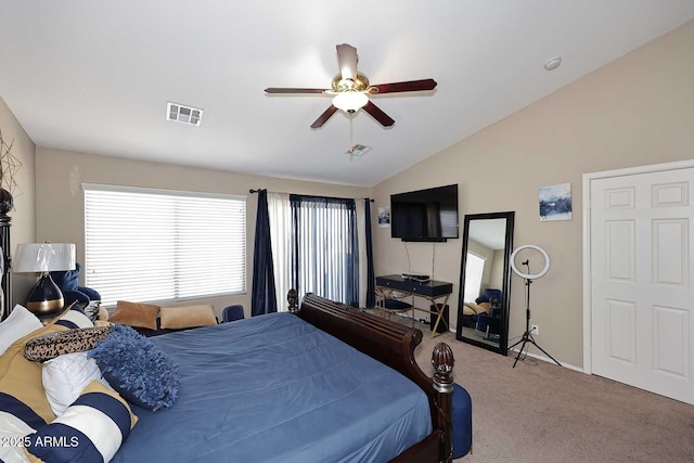 bedroom featuring carpet floors, visible vents, vaulted ceiling, and a ceiling fan