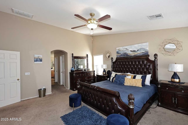 bedroom with light carpet, visible vents, arched walkways, and vaulted ceiling