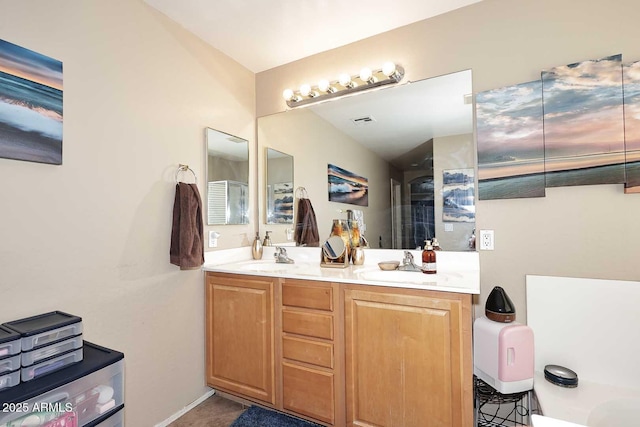 bathroom with double vanity, visible vents, and a sink