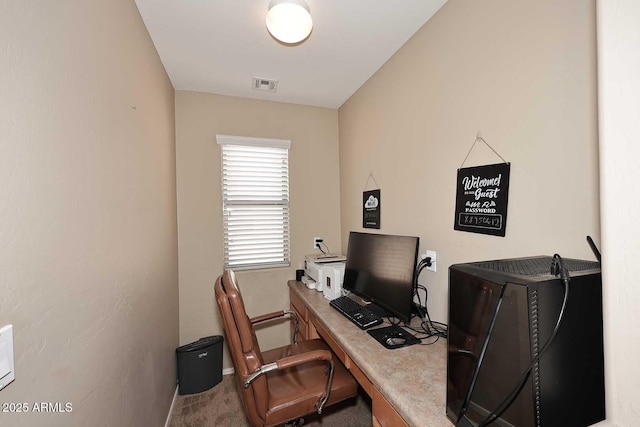 carpeted office space with visible vents and baseboards