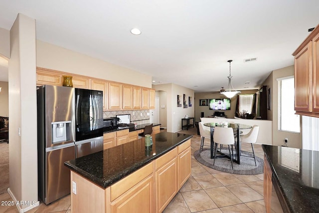 kitchen featuring tasteful backsplash, visible vents, stainless steel fridge with ice dispenser, a kitchen island, and light brown cabinets