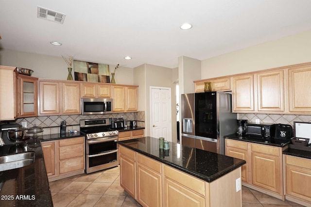 kitchen with visible vents, light brown cabinetry, appliances with stainless steel finishes, light tile patterned flooring, and a kitchen island