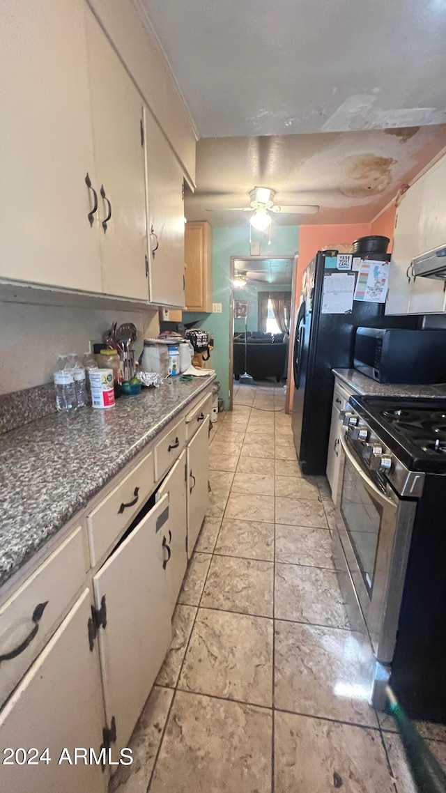 kitchen featuring light tile flooring, ceiling fan, stone counters, appliances with stainless steel finishes, and white cabinetry