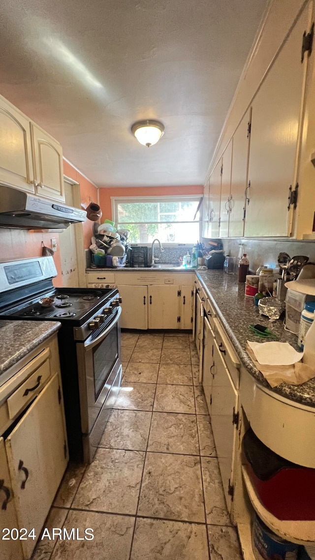 kitchen with light tile floors, double oven range, and sink