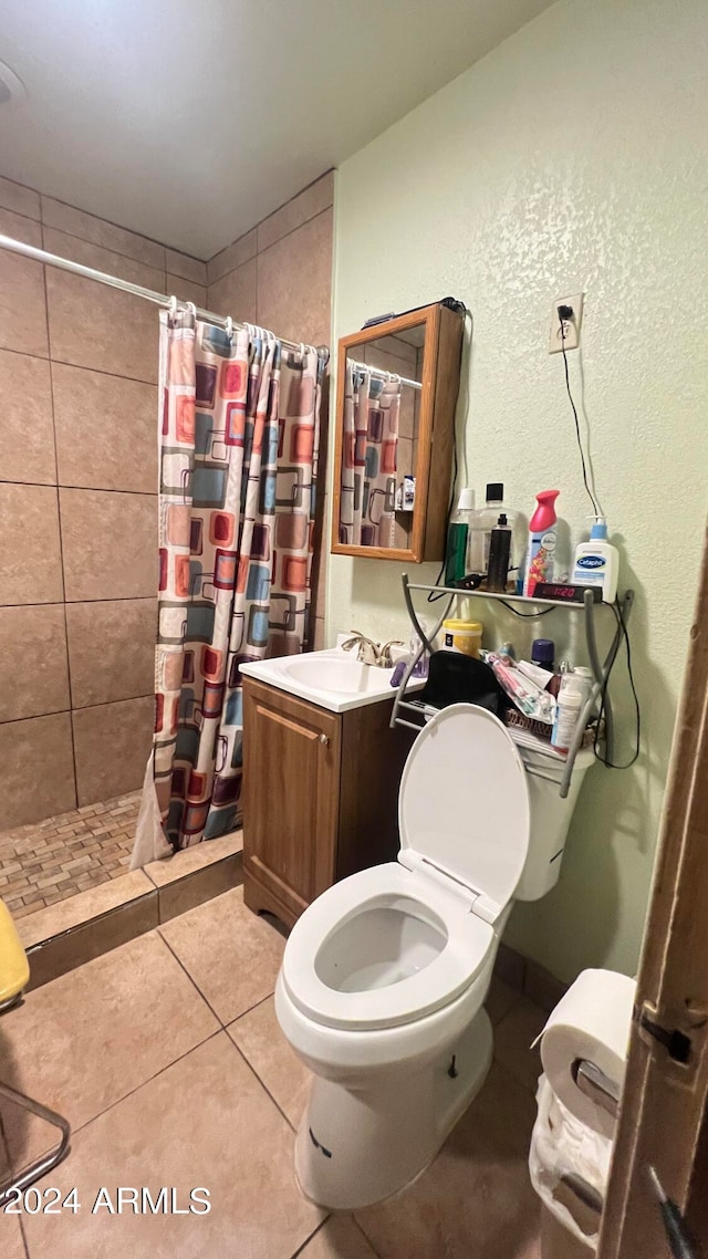 bathroom featuring a shower with curtain, tile flooring, toilet, and vanity with extensive cabinet space