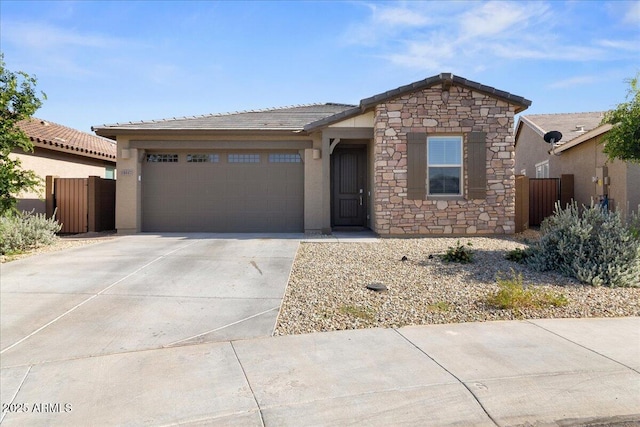 19447 W Mariposa Dr, Litchfield Park, AZ 85340 - view of front facade with concrete driveway, an attached garage, stone siding, and fence