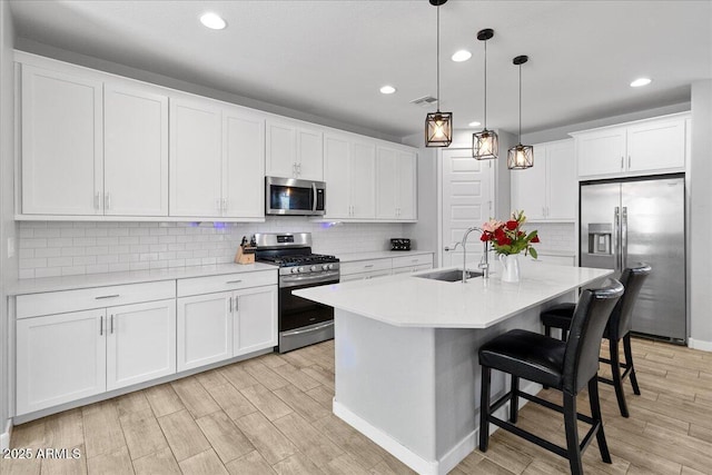 19447 W Mariposa Dr, Litchfield Park, AZ 85340 - kitchen featuring appliances with stainless steel finishes, a sink, light wood finished floors, light countertops, and recessed lighting