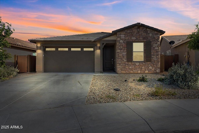 19447 W Mariposa Dr, Litchfield Park, AZ 85340 - view of front of property featuring stone siding, a garage, driveway, and fence