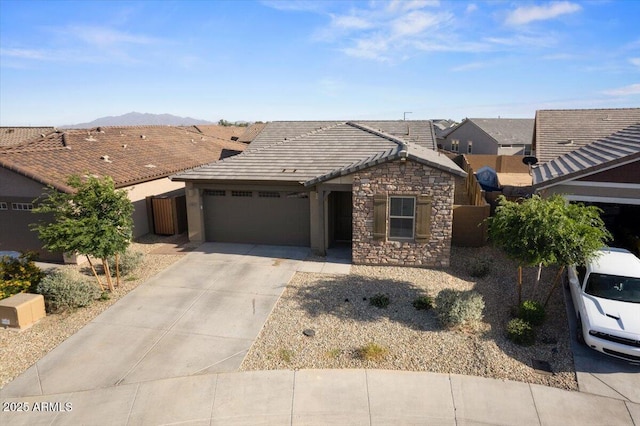 19447 W Mariposa Dr, Litchfield Park, AZ 85340 - ranch-style home with a garage, concrete driveway, stone siding, a mountain view, and a tiled roof