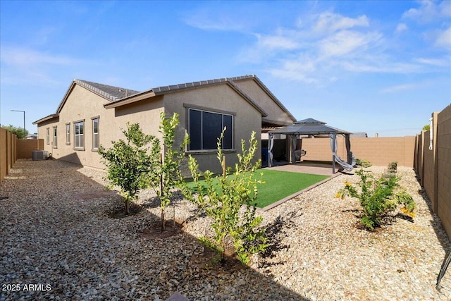 19447 W Mariposa Dr, Litchfield Park, AZ 85340 - rear view of property featuring a gazebo, cooling unit, stucco siding, a fenced backyard, and a patio