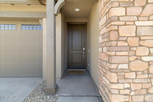 19447 W Mariposa Dr, Litchfield Park, AZ 85340 - doorway to property featuring a garage, stone siding, and stucco siding