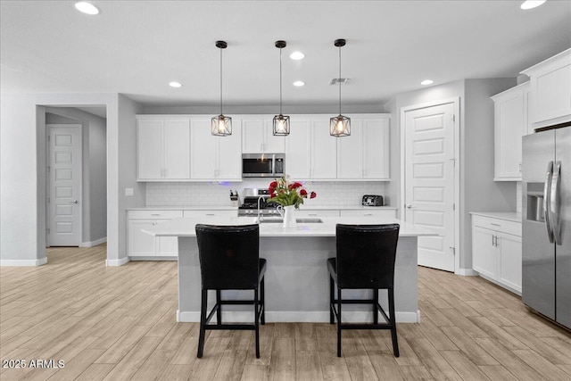19447 W Mariposa Dr, Litchfield Park, AZ 85340 - kitchen with stainless steel appliances, recessed lighting, backsplash, a center island with sink, and light countertops
