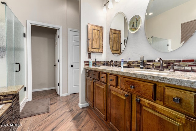 bathroom with a shower with door, vanity, and hardwood / wood-style flooring