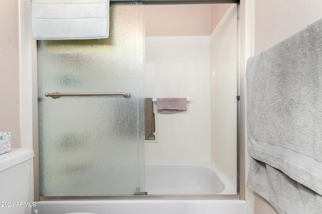 bathroom featuring toilet and enclosed tub / shower combo