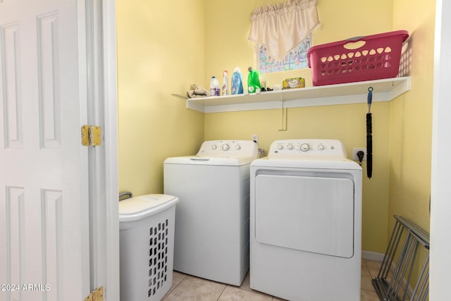 clothes washing area with washing machine and clothes dryer and light tile patterned floors