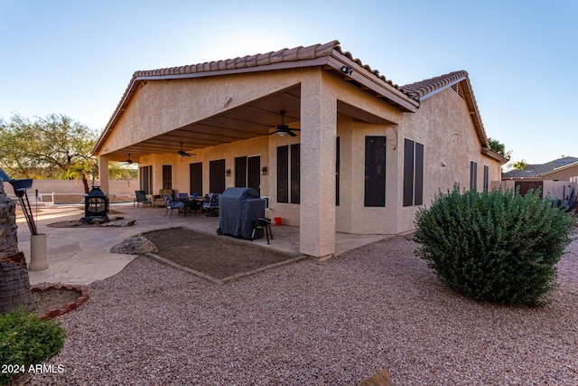 rear view of house with ceiling fan and a patio area