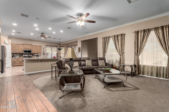 living room featuring light hardwood / wood-style flooring, ceiling fan, and crown molding