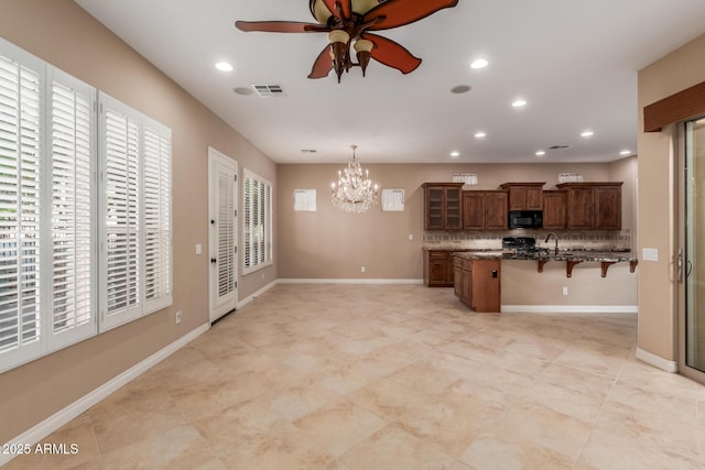 1260 E Sweet Citrus Dr, Queen Creek, AZ 85140 - kitchen featuring black microwave, a breakfast bar area, ceiling fan, recessed lighting, and a chandelier