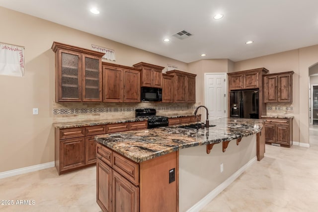 1260 E Sweet Citrus Dr, Queen Creek, AZ 85140 - kitchen with black appliances, a sink, decorative backsplash, a kitchen breakfast bar, and dark stone countertops