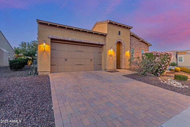 1260 E Sweet Citrus Dr, Queen Creek, AZ 85140 - mediterranean / spanish-style house featuring a garage, decorative driveway, and stucco siding