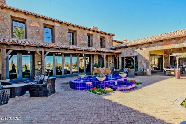 1260 E Sweet Citrus Dr, Queen Creek, AZ 85140 - rear view of house with outdoor lounge area, a patio, and stone siding