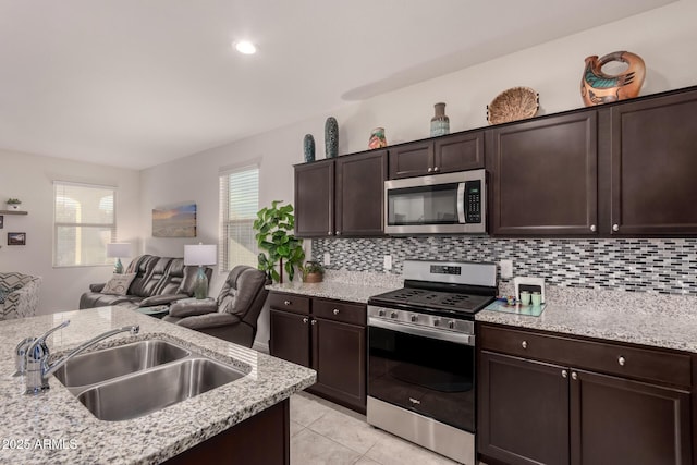 kitchen featuring appliances with stainless steel finishes, sink, dark brown cabinetry, and decorative backsplash