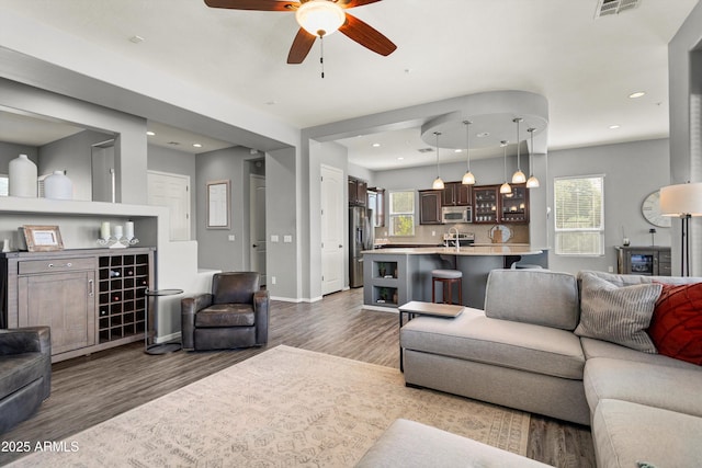 13072 W Alyssa Ln, Peoria, AZ 85383 - living room featuring wood finished floors, a ceiling fan, recessed lighting, baseboards, and a dry bar