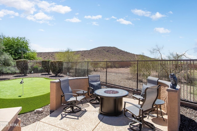 13072 W Alyssa Ln, Peoria, AZ 85383 - view of patio / terrace featuring a putting green, an outdoor fire pit, and a mountain view