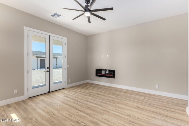 unfurnished living room featuring french doors, heating unit, light hardwood / wood-style floors, and ceiling fan