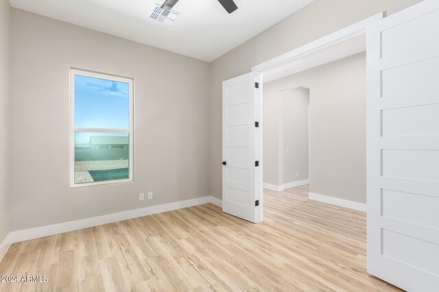 unfurnished room with light wood-type flooring and ceiling fan