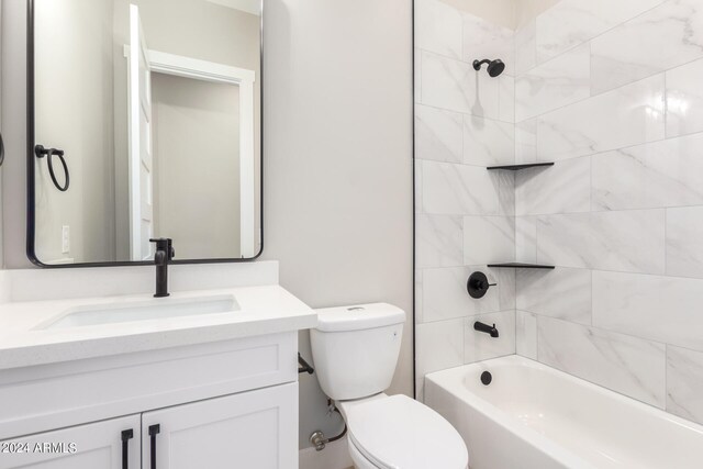 full bathroom featuring vanity, tiled shower / bath combo, and toilet