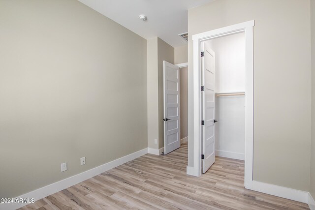 unfurnished bedroom featuring light wood-type flooring and a closet