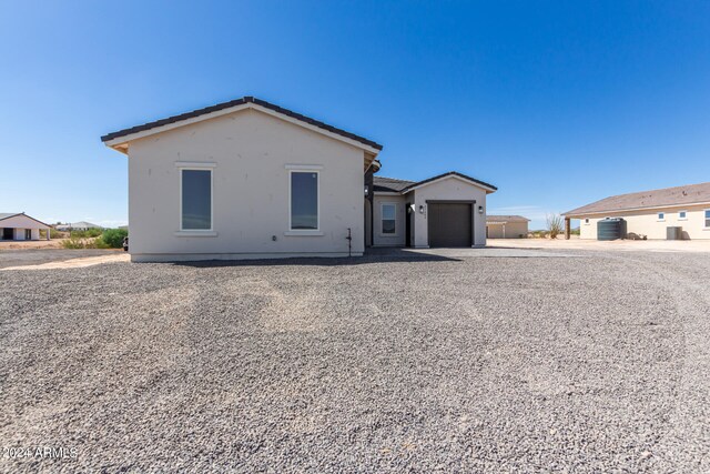 single story home featuring central air condition unit and a garage