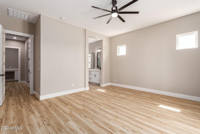 unfurnished bedroom with multiple windows, ceiling fan, light hardwood / wood-style flooring, and ensuite bathroom