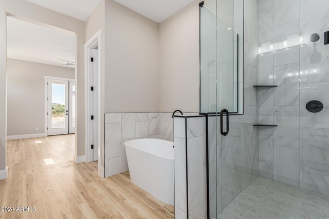 bathroom with plus walk in shower and hardwood / wood-style flooring