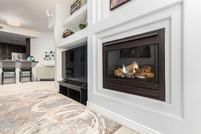 interior details featuring carpet floors and stainless steel fridge with ice dispenser